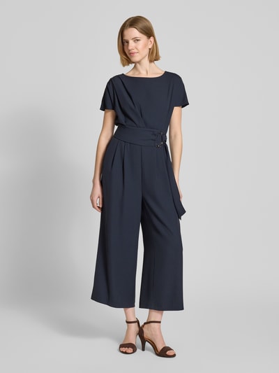 Vrouwenmodel draagt Jumpsuit mit Stretch-Anteil van Betty Barclay in donkerblauw met riem, regular fit, 7/8-lengte, materiaal-mix, plooien, ronde hals, korte mouwen, voorkant volledige lichaamsweergave.