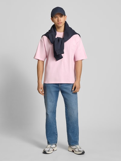 Mannermodel draagt Oversized T-shirt met Logo en Rundhalsausschnitt van REVIEW, puur katoen, oversized fit, logoprint; ganzlichaamsaanzicht van voren.