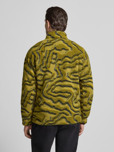 Männermodel trägt Regular Fit Pullover mit Logo-Patch von Columbia in gelb-grüner Fließ-Optik, elastische Abschlüsse, Ganzkörperansicht Rückansicht.
