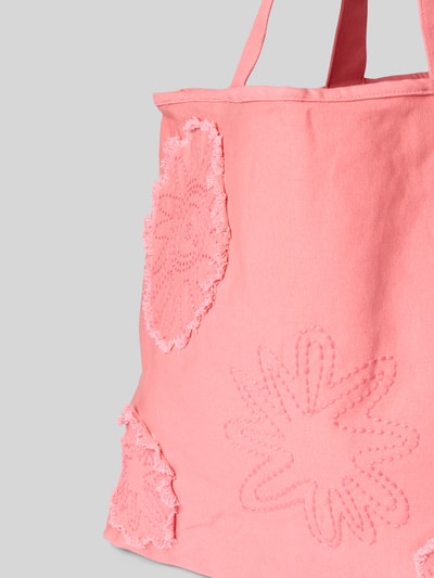 Produktfoto, Strandtasche aus Baumwolle Modell 'Dieuw' von Barts in Rosa, strukturierte Blütenmuster, sichtbare Tragehenkel, Hauptfach mit Schnürung, Innenfach mit Reißverschluss, Maße 53x39x19 cm, Schulterriemen 52 cm, Nahaufnahme seitlich