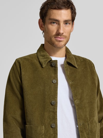 Männermodel trägt Hemdjacke mit Eingrifftaschen Modell 'HOLMDRUP' von Casual Friday in Olivgrün, Baumwoll-Mix, Nahaufnahme Oberkörper. Regular Fit, Kentkragen, sichtbare Knopfleiste, strukturierte Cord-Textur, dezent meliert, für Herren, Stretch-Anteil im Stoff, Rückenlänge bei Größe M 67 cm.