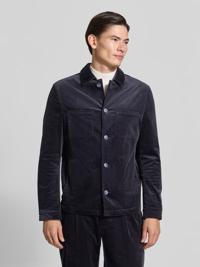 Männermodel trägt Slim Fit Hemdjacke aus Cord von MCNEAL in Dunkelblau, Knopfleiste, Brusttaschen, Baumwoll-Elasthan-Mix, Ganzkörperansicht von vorne.