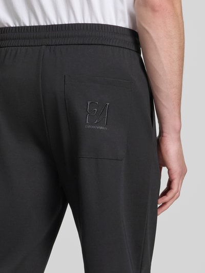 Männermodel trägt Sweatpants mit elastischem Bund von Emporio Armani aus Lyocell-Mix mit Viskose-Anteil, Relaxed-Fit, Nahaufnahme Rückansicht.