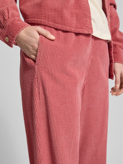 Frauenmodel trägt Stoffhose mit elastischem Bund Modell 'PADOW' von American Vintage aus reiner Viskose in Rosa, Nahaufnahme Hüfte.