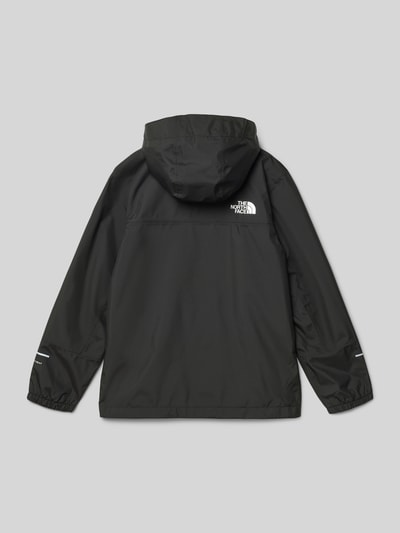 Junge trägt schwarze Regenjacke mit Label-Print Modell 'ANTORA' von The North Face, reflektierende Prints, Ganzkörperansicht Rückansicht