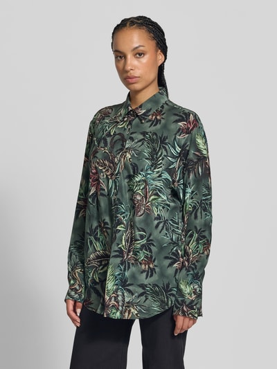 Frauenmodel trägt Hemdbluse mit floralem Allover-Print von Rabanne, dunkelgrün mit bunten Blumen und entspanntem Schnitt, Kentkragen, Nietenbesatz, langärmelige Ausführung, Textur glatt, Ganzkörperansicht von vorne.