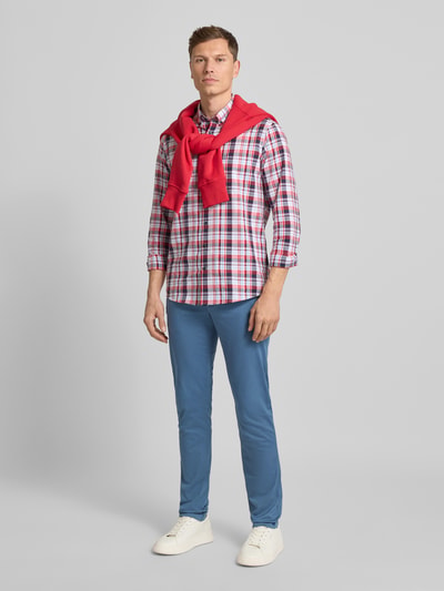 Męski model nosi niebieskie Slim Fit Chino aus Baumwoll-Mix Modell 'BLEECKER' od Tommy Hilfiger, gładki materiał, pełny widok z przodu.