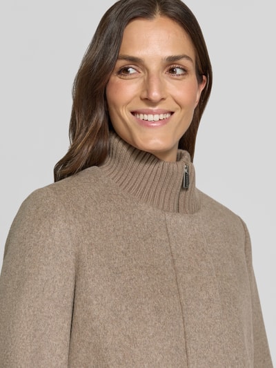 Vrouwenmodel draagt Jacke aus Woll-Mix met gestricktem opstaande kraag van comma, beige, met viscose, gebreide textuur, Nahaufnahme Oberkörper. Ruglengte maat 36: 62 cm, schouderbreedte: 36 cm, borstwijdte: 53 cm, mouwlengte: 64 cm.