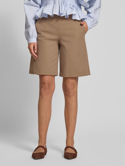 Frauenmodel trägt Schlupfbermuda Techno Cotton Superstretch von Raffaello Rossi, Regular-Fit, elastischer Bund, Gesäßtaschen, Modell ISKA, Bundweite 39 cm, Innenbeinlänge 24 cm, sandfarben, glatte Oberfläche, Ganzkörperansicht von vorne.