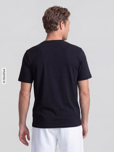 Männermodel trägt T-Shirt mit Rundhalsausschnitt von MCNEAL in Schwarz, reine Baumwolle, Slim Fit, Rückenlänge 68 cm, Ganzkörperansicht Rückansicht.