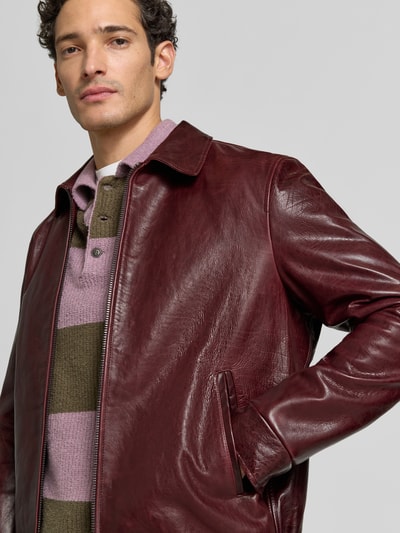 Männermodel trägt Regular Fit Jacke in Leder-Optik mit Umlegekragen von Emporio Armani in Dunkelrot, Zweiwege-Reißverschluss, Nahaufnahme Oberkörper.