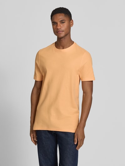 Männermodel trägt T-Shirt mit Rundhalsausschnitt von MCNEAL in Orange, reine Baumwolle, Slim Fit, glatte Textur, Ganzkörperansicht von vorne.