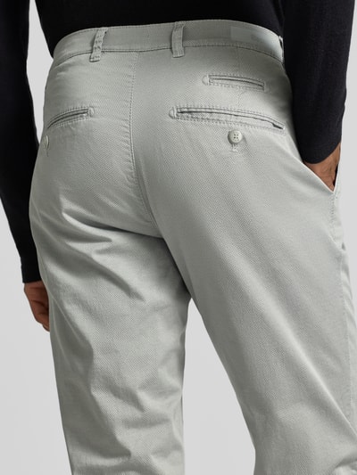 Männermodel trägt fein strukturierte Hose Modell 'Fabio' von BRAX aus Baumwoll-Elasthan-Mix mit Eingrifftaschen, Regular-Fit, Ganzkörperansicht Rückansicht.