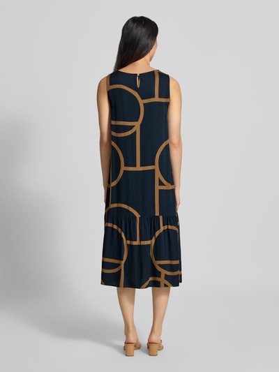 Männermodel trägt Ausgestelltes Freizeitkleid aus reiner Viskose Modell 'Wicy atelier' von OPUS, granatowy z brązowym geometrycznym wzorem, gładka faktura, sukienki casualowe damen Freizeitkleid von OPUS, Ganzkörperansicht Rückansicht.