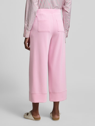 Vrouwenmodel draagt Wide Leg Sweatpants met steekzakken van Rich & Royal, modalmix met stretch, wide leg, elastische band, binnenbeenlengte maat S 63 cm, lichtroze kleur, gladde textuur, rechte vormen, geheel zicht van achteren.