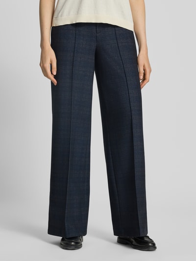 Kobieta nosi spodnie 'Wide Fit Hose mit Viskose-Anteil' od Oui, mieszanka wiskozy, ozdobne szwy, kieszenie z tyłu, zapięcie na haftkę i zamek błyskawiczny, ciemnoniebieskie, szerokie nogawki, szerokość w rozmiarze 36: 39 cm, długość wewnętrzna nogawki: 80 cm, widok na całe ciało z przodu.