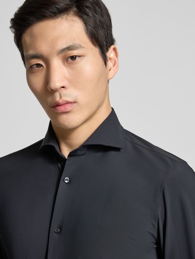 Männermodel trägt schwarzes Slim Fit Business-Hemd mit Kentkragen von JOOP! Collection, glatte Textur, Nahaufnahme Oberkörper.