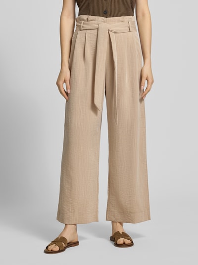 Frauenmodel trägt Regular Fit Bundfaltenhose aus Viskose-Mix Modell 'MARSA' von Only in Beige mit Bindegürtel, Nahaufnahme Unterkörper.