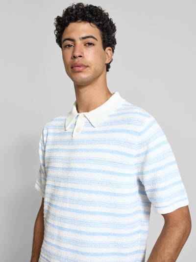 Männermodel trägt Modern Fit Poloshirt mit kurzer Knopfleiste Modell 'HYERES' von Jack & Jones, Strukturmuster, Nahaufnahme Oberkörper.