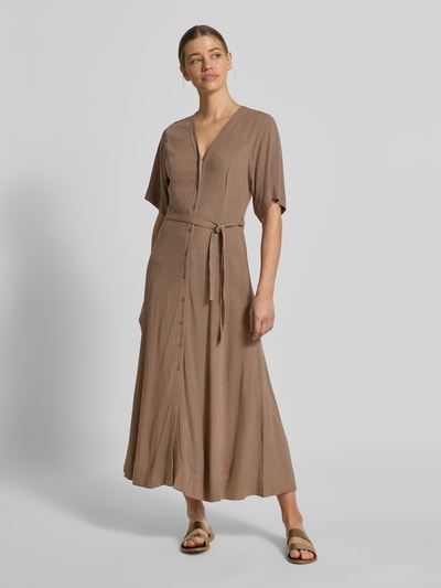Modelka kobieca nosi Regular Fit Leinenkleid mit V-Ausschnitt Modell 'VIVA' von Selected Femme, jednolity kolor, bez rękawów, pasek, lniana tekstura, długość maxi, zapięcie na guziki, boczne kieszenie, widok całej sylwetki z przodu