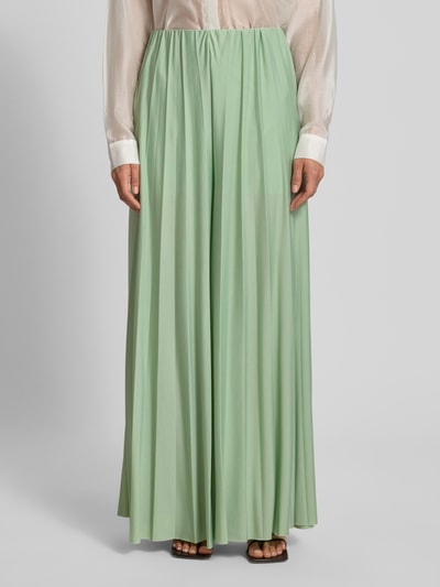 Vrouwenmodel draagt stoffen broek van satijn in pastelgroen met plissévouwen, wide leg fit, model 'Samantha' van GUIDO MARIA KRETSCHMER WOMAN, elastische band, binnenbeenlengte maat 36: 73 cm, bandwijdte maat 36: 34 cm, voorkant tot enkel, close-up onderlichaam