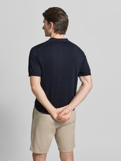 Männermodel trägt Regular Fit Poloshirt mit Knopfleiste Modell 'BELLS' von Casual Friday aus Baumwoll-Lyocell-Mix, Rückenlänge bei Größe M 70 cm, Strickshirt in Dunkelblau, Ganzkörperansicht Rückansicht.