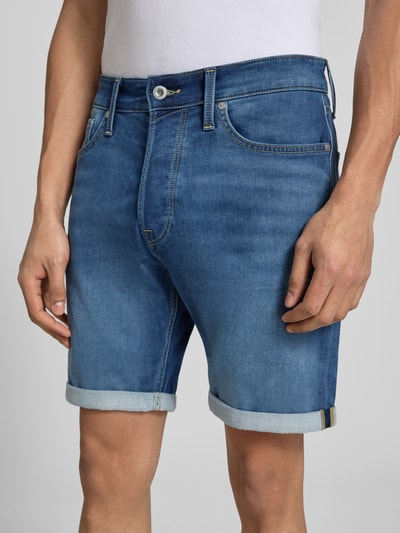 Męski model nosi Regular Fit Jeansshorts mit Umschlag Modell 'RICK' od Jack & Jones, bawełniany miks z wiskozą, wygląd used, szerokość w rozmiarze M: 42 cm, długość nogawki wewnętrznej: 20 cm, zdjęcie: zbliżenie na górną część ciała.