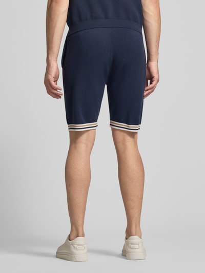Männermodel trägt Shorts mit elastischem Bund und Eingrifftaschen von Christian Berg Men, dunkelblau, Baumwolle, Ganzkörperansicht Rückansicht.