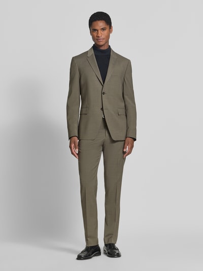 Männermodel trägt Regular Fit Sakko mit Woll-Anteil Modell 'Jamie' von Tiger of Sweden in Olive, feine Textur, glatte Oberfläche, Ganzkörperansicht von vorne. Sakko mit Reverskragen, 2-Knopfleiste, Pattentaschen, elastischer Material-Mix, Rückenlänge 73 cm, Schulterbreite 43 cm, Ärmellänge 66 cm.