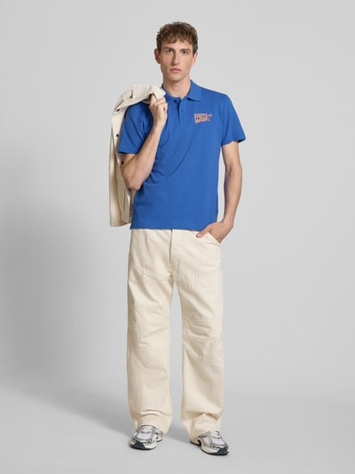 Männermodel trägt Regular Fit Poloshirt mit Print und Knopfleiste Modell 'MAILLE' von Blend in Blau, reine Baumwolle, Ganzkörperansicht von vorne.