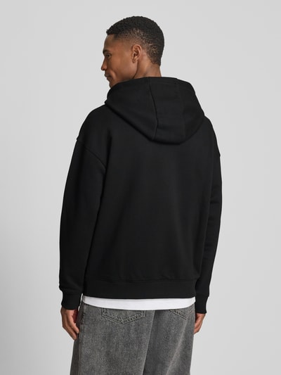 Männermodel trägt Regular Fit Hoodie aus reiner Baumwolle Modell 'DAGETHOOD' von HUGO, Optik: Unifarben, Sweat, Ganzkörperansicht Rückansicht.
