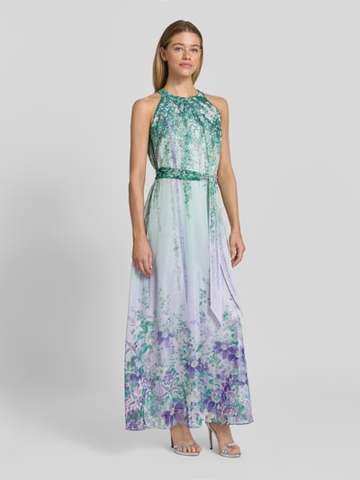 Frauenmodel trägt Maxikleid mit Bindegürtel von Marc Cain, Damen A-Linie, Neckholder, Allover-Look, lila-grün, Ganzkörperansicht von vorne.