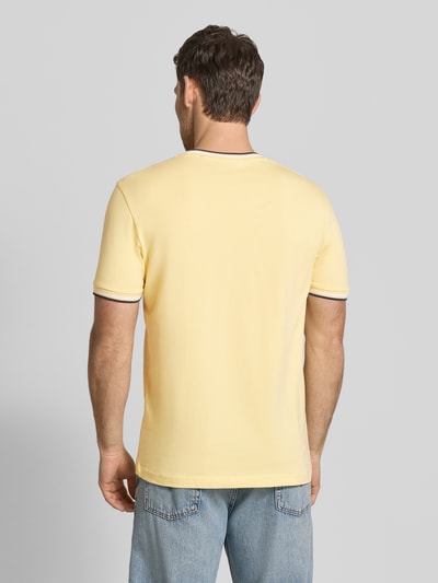 Mężczyzna nosi T-Shirt mit Kontraststreifen und Rundhalsausschnitt von Christian Berg Men, bawełna z elastanem, krój regular fit, cienkie kontrastowe paski, żółty, długość tyłu w rozmiarze M: 71 cm, widok całej sylwetki z tyłu.