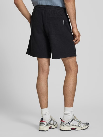 Männermodel trägt Regular Fit Sweatshorts aus Baumwoll-Mix von Marc O'Polo Denim, Optik: Unifarben, Materialverarbeitung: Bouclé, Gesäßtasche, Ganzkörperansicht Rückansicht.