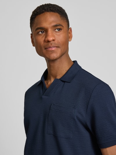 Männermodel trägt Regular Fit Poloshirt aus Baumwoll-Mix von s.Oliver RED LABEL, Optik: Unifarben, Struktur, Kurzarm, Brusttasche, Nahaufnahme Oberkörper.