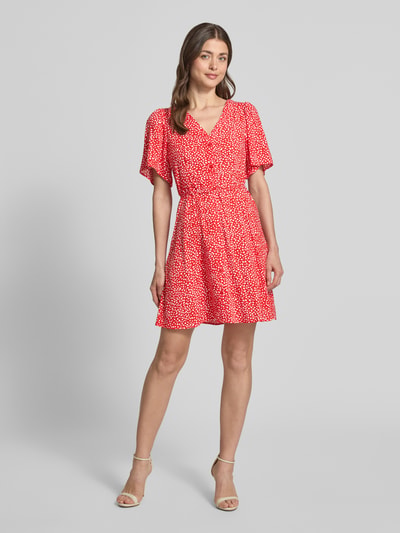 Frauenmodel trägt Leicht ausgestelltes Minikleid aus reiner Viskose Modell 'ALBA' von Vero Moda, Optik: Unifarben, Passform: Leicht ausgestellt, Länge: Mini, Ausschnitt: V-Ausschnitt, Details: Taillengürtel, Verschluss: Knopfleiste, Ärmelform: Kurzarm, Material: Reine Viskose, Ganzkörperansicht von vorne