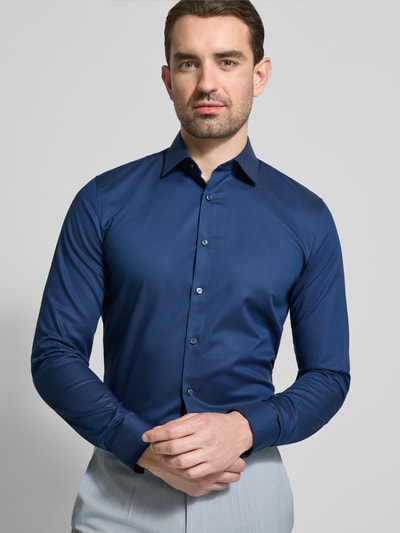 Männermodel trägt Super Slim Fit Business-Hemd mit Kentkragen und Strukturmuster von OLYMP, dunkles Blau, Baumwoll-Elasthan-Mix, Ganzkörperansicht von vorne. Rückenlänge 80 cm, Schulterbreite 44 cm, Ärmellänge 66 cm, Größe 40.