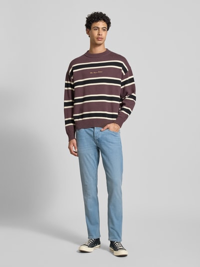 Männermodel trägt Straight Fit Jeans im 5-Pocket-Design Modell 'Glenn' von JACK & JONES aus elastischem Baumwoll-Mix, hellblau, Ganzkörperansicht von vorne.