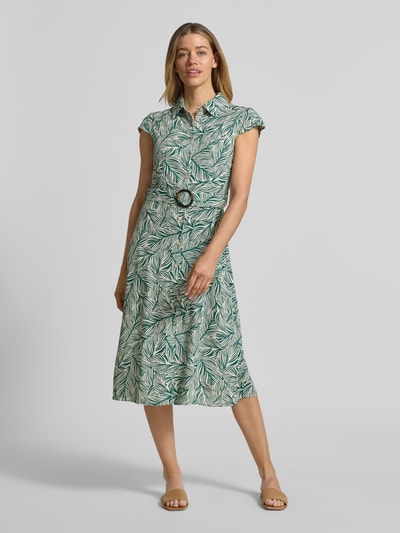 Frauenmodel trägt Midikleid aus Viskose-Mix mit Leinen-Anteil von Apricot mit floralem Allover-Muster und Stoffgürtel, Ganzkörperansicht von vorne.