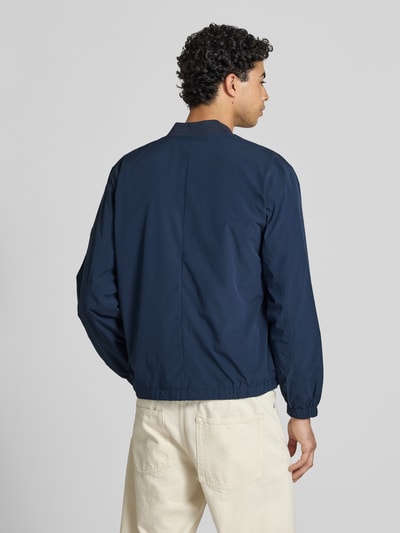 Männermodel trägt Regular Fit Bomberjacke mit College-Kragen Modell 'BELVEDERE' von Pepe Jeans in Dunkelblau, unifarben, Rückansicht Ganzkörperansicht.