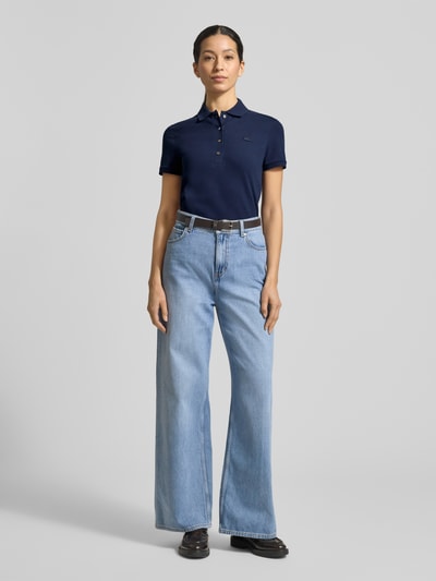 Frauenmodel trägt Regular Fit Poloshirt aus Baumwoll-Mix von Lacoste Sport in Dunkelblau, unifarben, mit Polokragen und Logo-Stitching, Piqué-Struktur, Ganzkörperansicht von vorne.