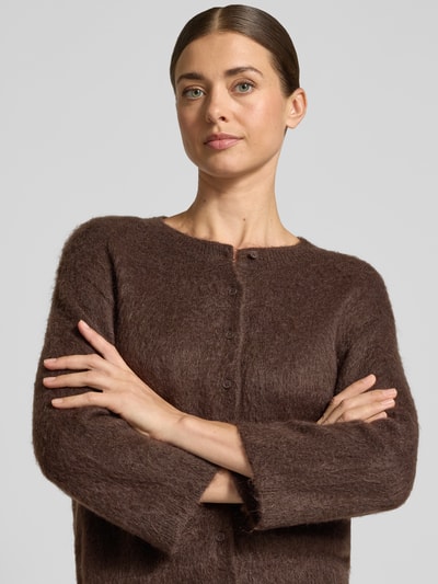 Frauenmodel trägt Strickjacke aus Woll-Mohair-Mix Modell 'Disille' von OPUS, braun, unifarben, Rundhals, 3/4-Arm, Nahaufnahme Oberkörper.