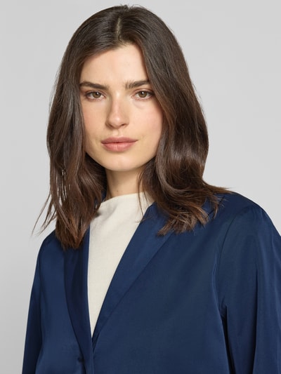 Frauenmodel trägt Relaxed Fit Mantel mit Reverskragen von WHITE LABEL in Dunkelblau, glatte Textur, Nahaufnahme Oberkörper. Rückenlänge 94 cm, Schulterbreite 38 cm, Brustweite 42 cm, Ärmellänge 63 cm bei Größe 36, mit Knopfleiste und Eingrifftaschen.