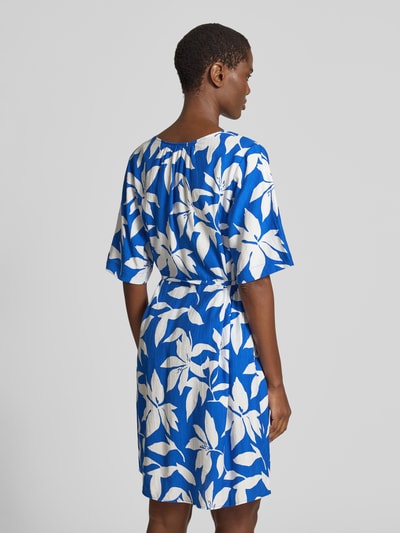 Frauenmodel trägt Relaxed Fix Freizeitkleid aus Viskose-Mix von s.Oliver RED LABEL, Optik:Allover-Muster in Blau und Weiß, Mini-Länge, Passform: Relaxed-Fit, V-Ausschnitt, Taillengürtel, Ärmelform: Kurzarm, Materialverarbeitung: Crinkle-Design, Ganzkörperansicht Rückansicht.