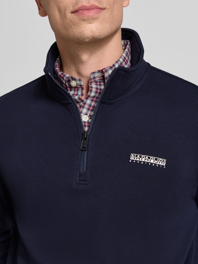 Männermodel trägt Relaxed Fit Sweatshirt aus elastischem Baumwoll-Mix von Napapijri in Dunkelblau mit Label-Detail, Nahaufnahme Oberkörper.