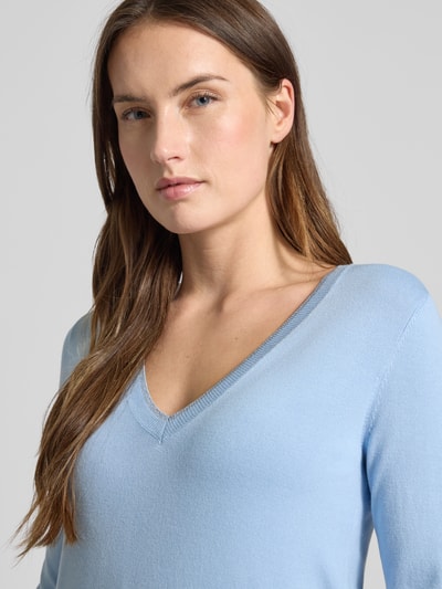 Frauenmodel trägt Slim Fit Longsleeve aus Viskose-Mix mit V-Ausschnitt von Liu Jo White in Hellblau, Logo-Detail, Nahaufnahme Oberkörper.