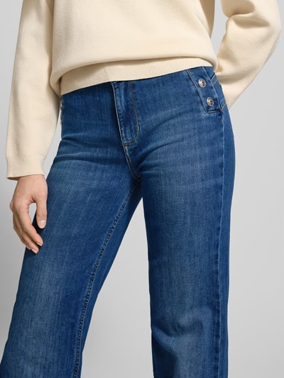 Kobiece model prezentuje Flared Jeans mit Knöpfen od Liu Jo White, denim niebieski, bawełniany z elastanem, używany wygląd, zbliżenie na górną część ciała.
