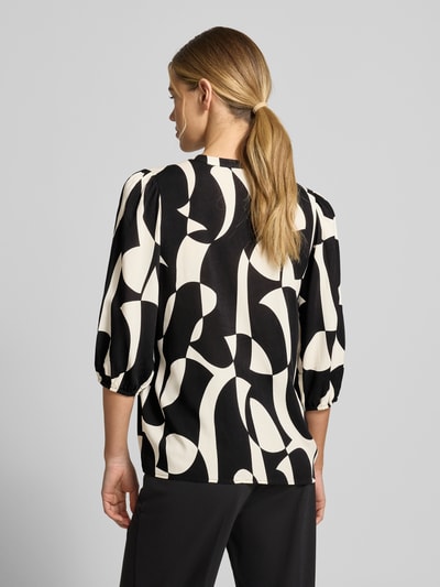 Frauenmodel trägt Regular Fit Bluse aus Reine Viskose Modell 'CHANISE' von Soyaconcept im Allover-Look mit Rundhalsausschnitt und 3/4-Arm, Rückenlänge bei Größe S 64 cm, Ärmellänge 45 cm, Schwarz-Weiß-Kontrast, Ganzkörperansicht Rückansicht.