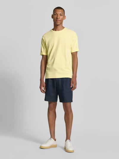 Männermodel trägt T-Shirt mit Ärmelaufschlag und Rundhalsausschnitt von Drykorn aus Reine Baumwolle im Regular-Fit, hellgelb, Rückenlänge 70 cm bei Größe M, Ganzkörperansicht von vorne.