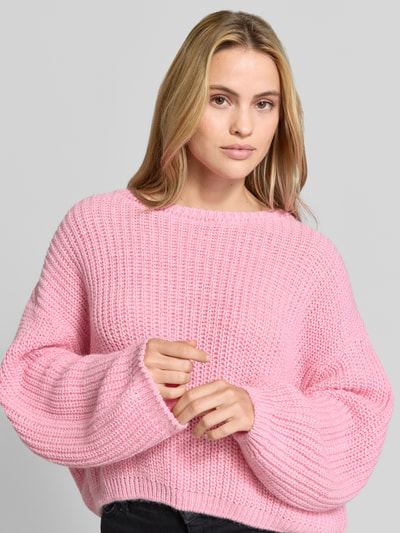 Vrouwenmodel draagt Oversized Strickpullover aus Leinen-Mix van American Vintage in roze, met lange mouwen, linnenmix, trendy look, Nahaufnahme bovenlichaam.